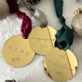 Gold mirror ornament with custom message and decorative ribbon.